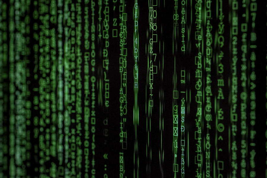 Linhas de código verdes em tela escura representando processamento de dados